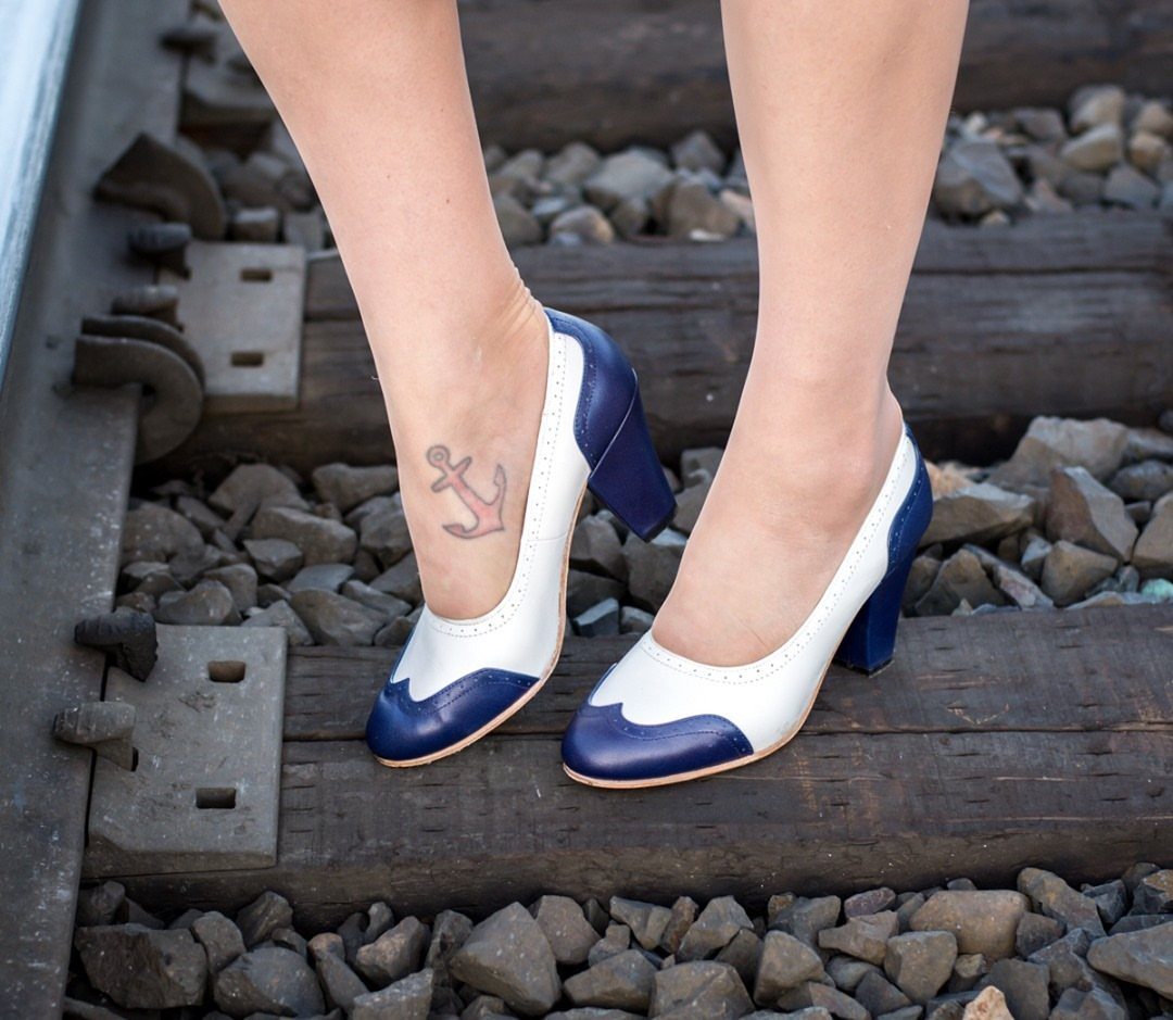 Two-tone white and navy blue high heel shoes on railroad tracks