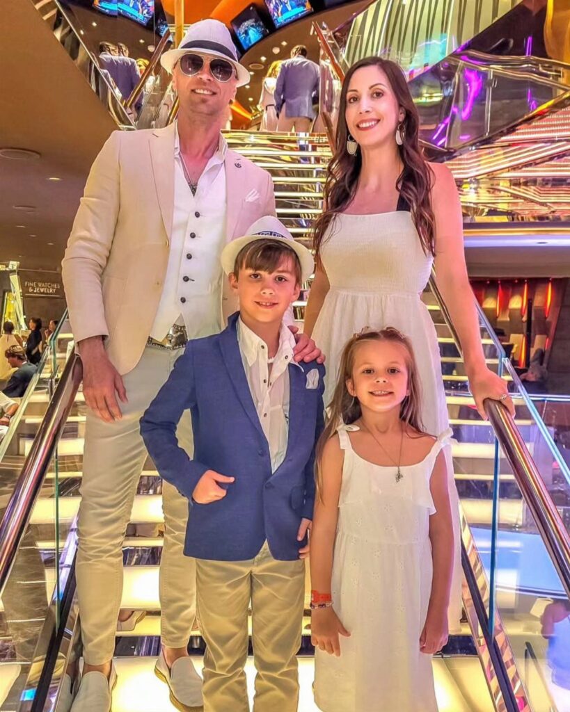 Family posing on cruise ship stairs with woman and girl in white dresses