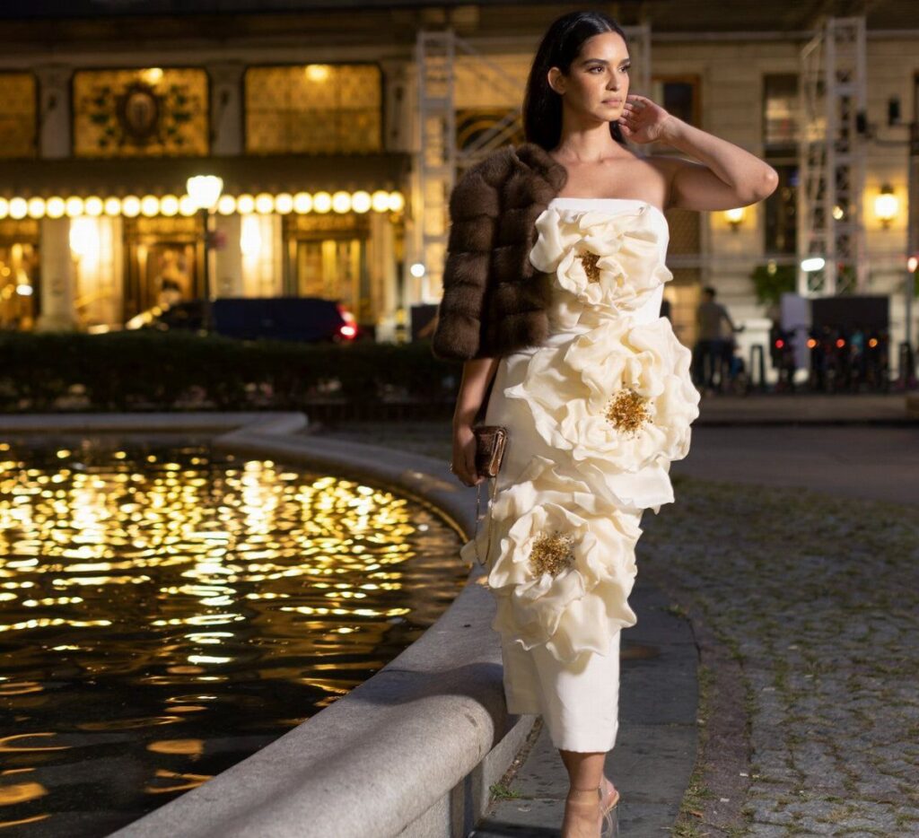 Woman in a strapless white tea-length dress with large 3D floral appliqués.