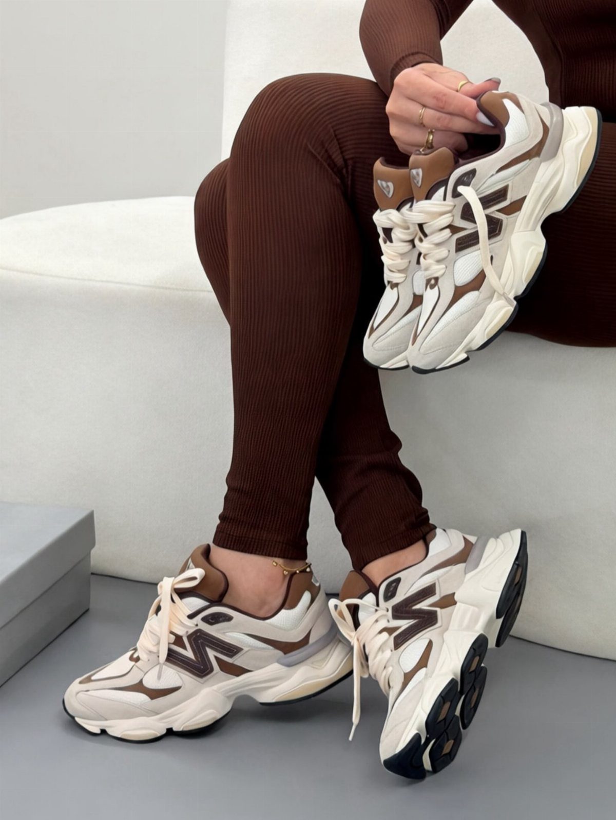 New Balance 9060 sneakers in white and brown worn with brown ribbed leggings.