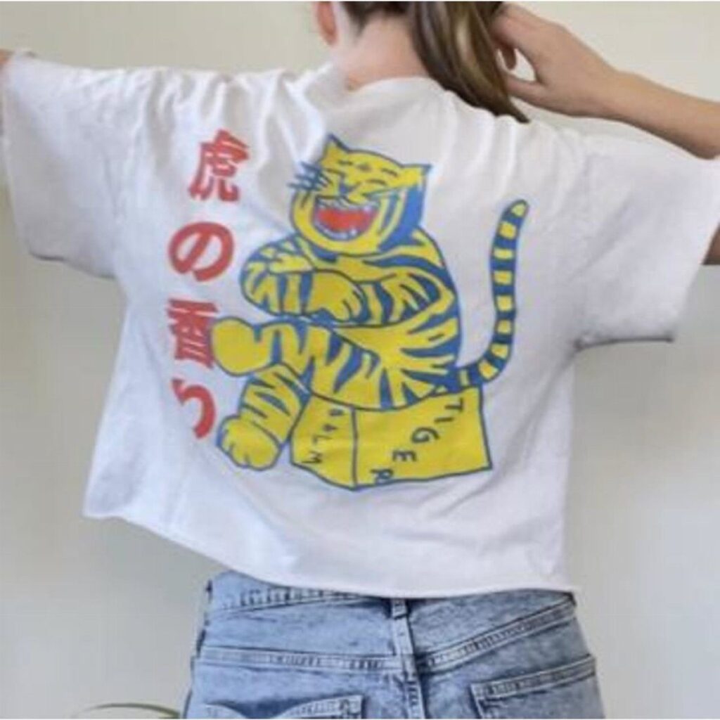 White t-shirt with a yellow tiger graphic and Japanese text on the back